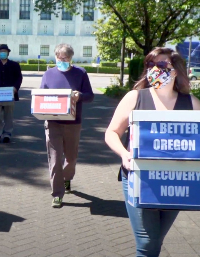 People carry boxes of signatures for Oregon's Measure 110 to decriminalize all drugs in Oregon.