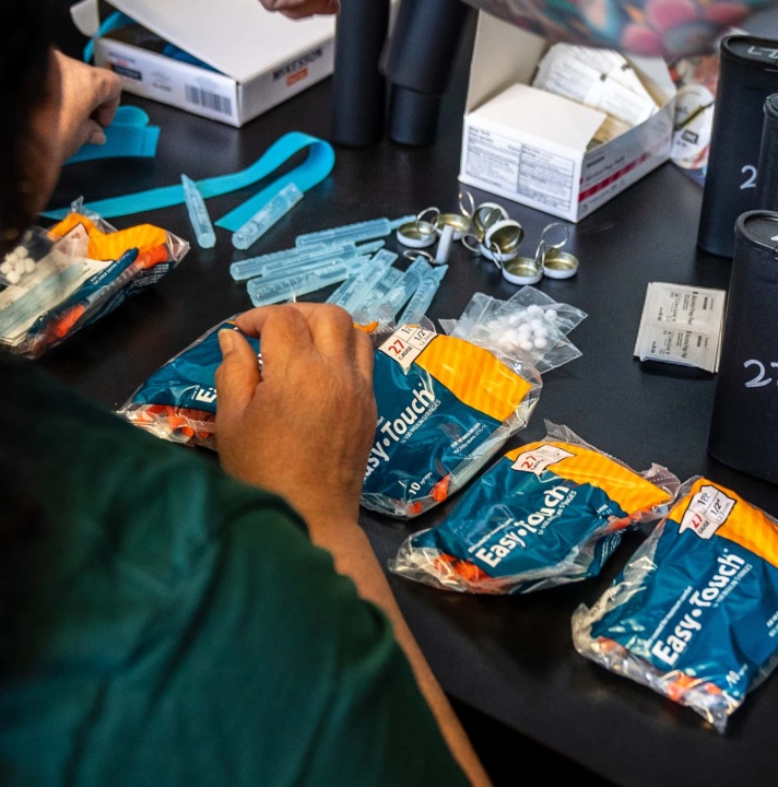 People assembling packets of supplies for safer drug use.