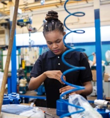 Photo of a woman at work building a machine.