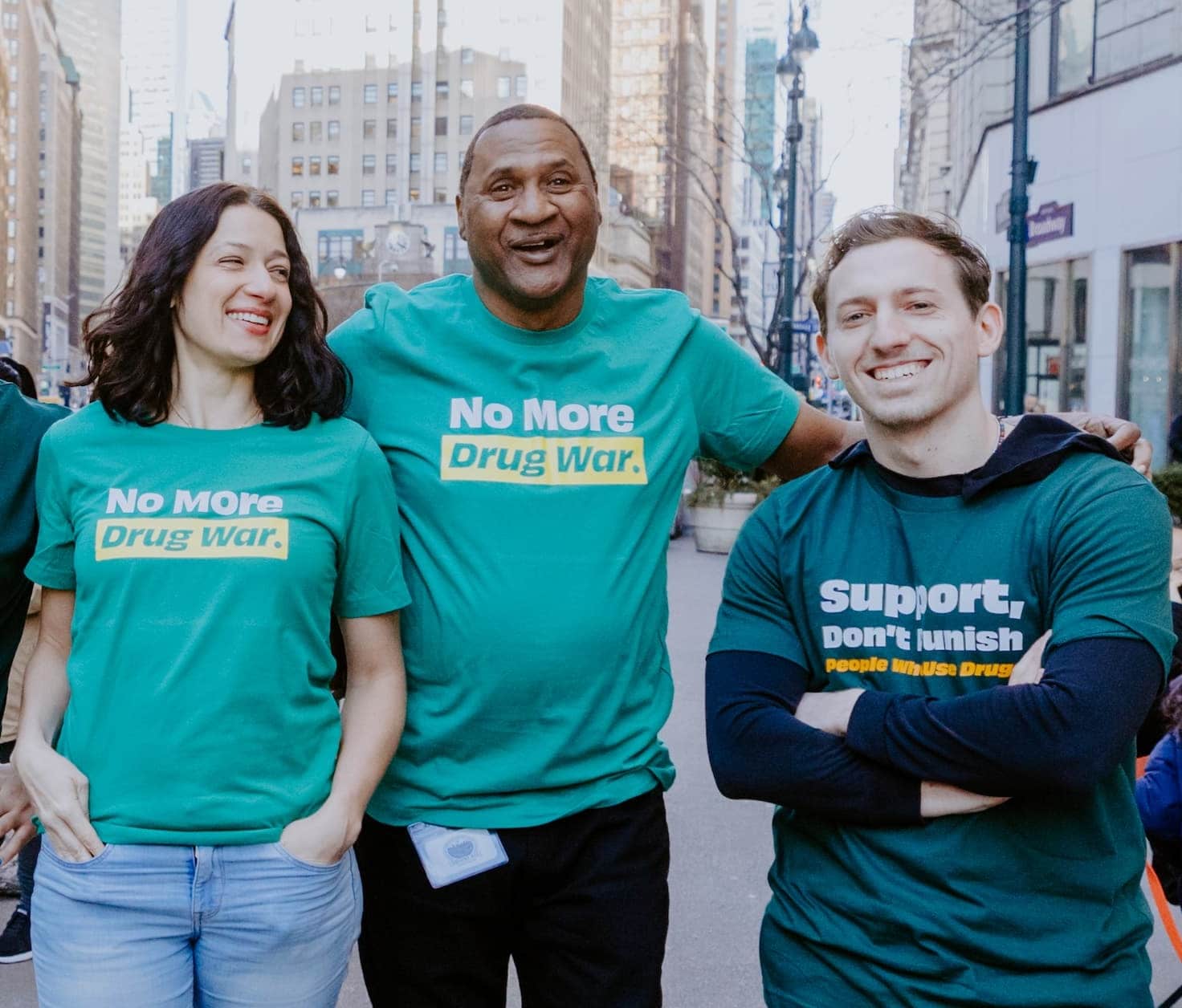 Photo of a woman and two men with green drug policy alliance shirts.